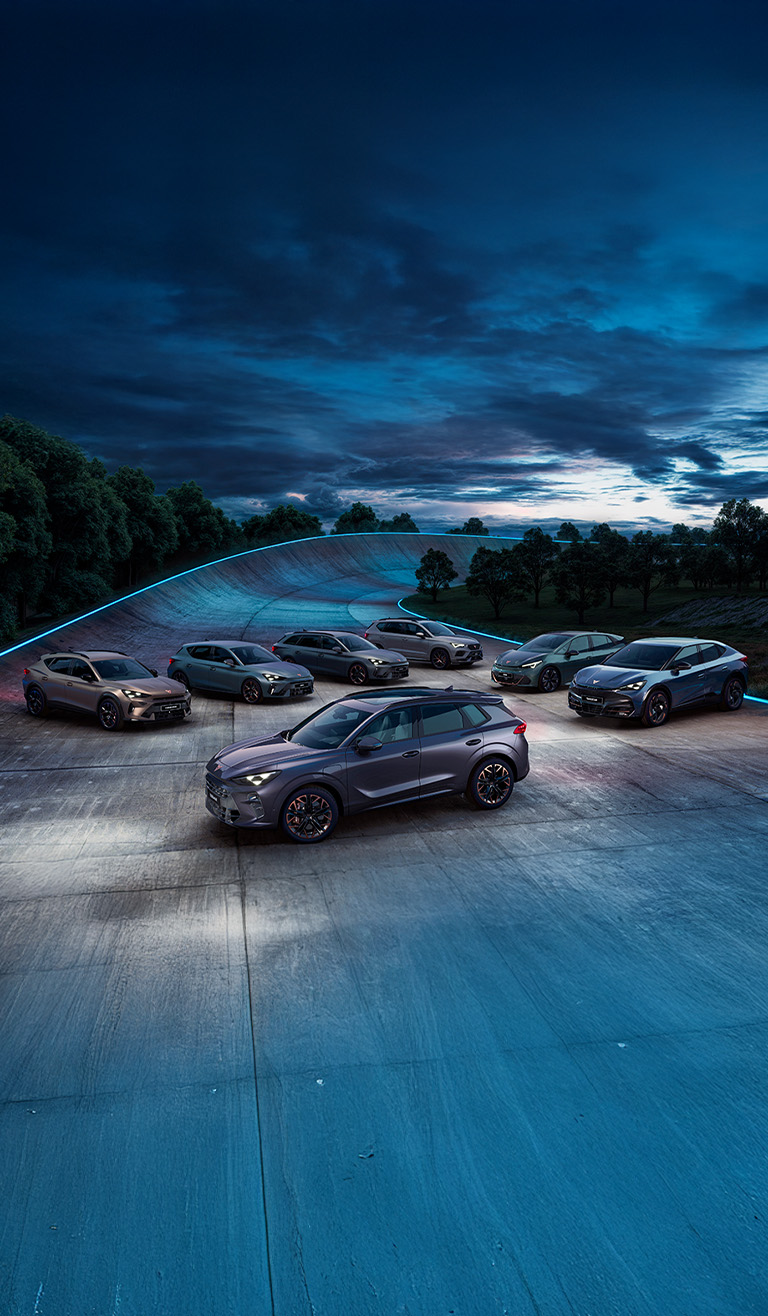 A person intently looking at their smartphone, standing outdoors with blurred modern city buildings and a bright sunset sky in the background.